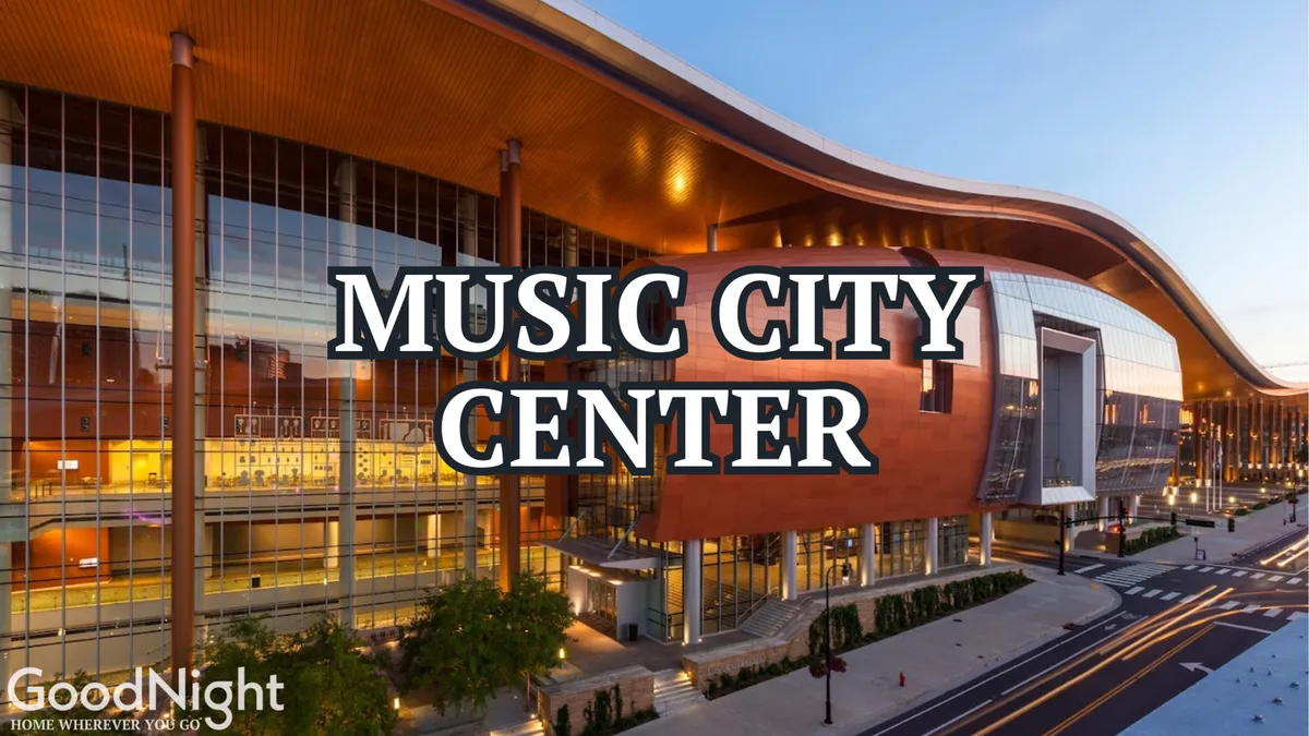 The image shows the distinctive facade and entrance area of the Music City Center, surrounded by modern landscaping. The building's contemporary architecture is prominent, indicating its status as a major conference and event hub in downtown Nashville.
